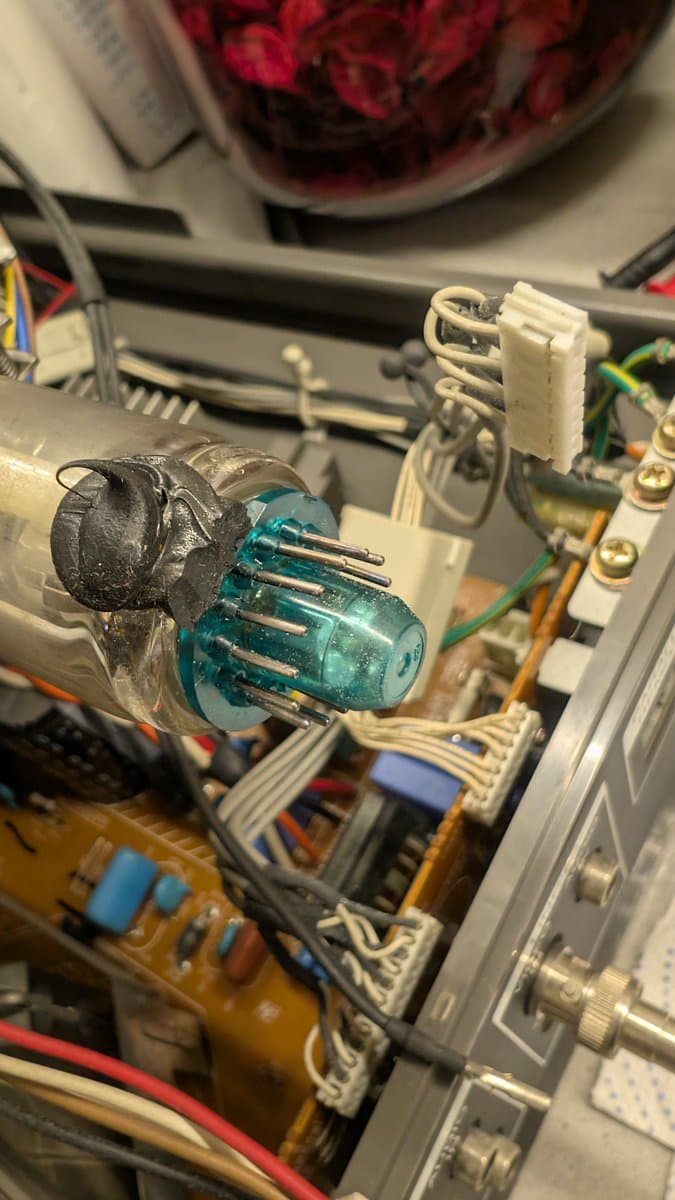 CRT tube pins being cleaned with fiberglass pen to remove oxidation; IPA and Deoxit applied during PVM-14L1 RGB mod maintenance.