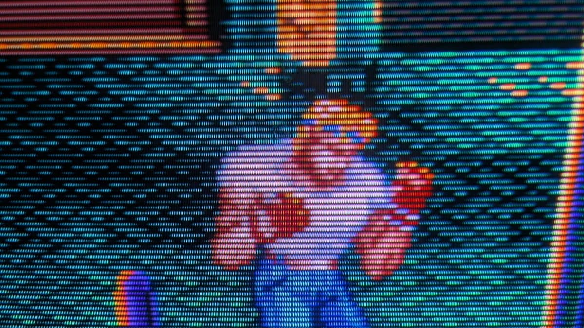 Sony PVM-14L1 displaying vibrant RGB test pattern with cyan, magenta, red, yellow, and blue vertical stripes on CRT screen.