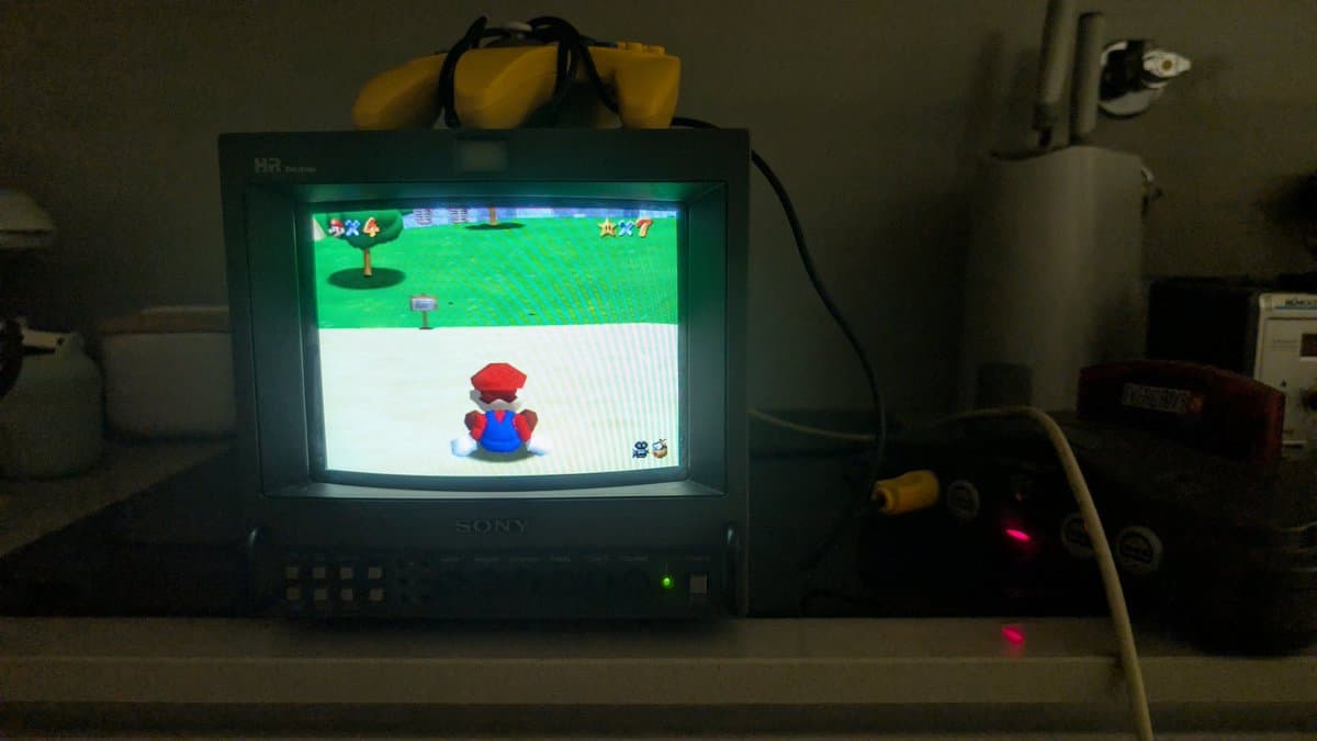 Restored Nintendo 64 running Super Mario 64 for validation testing on Sony CRT monitor with yellow capacitors visible atop unit.