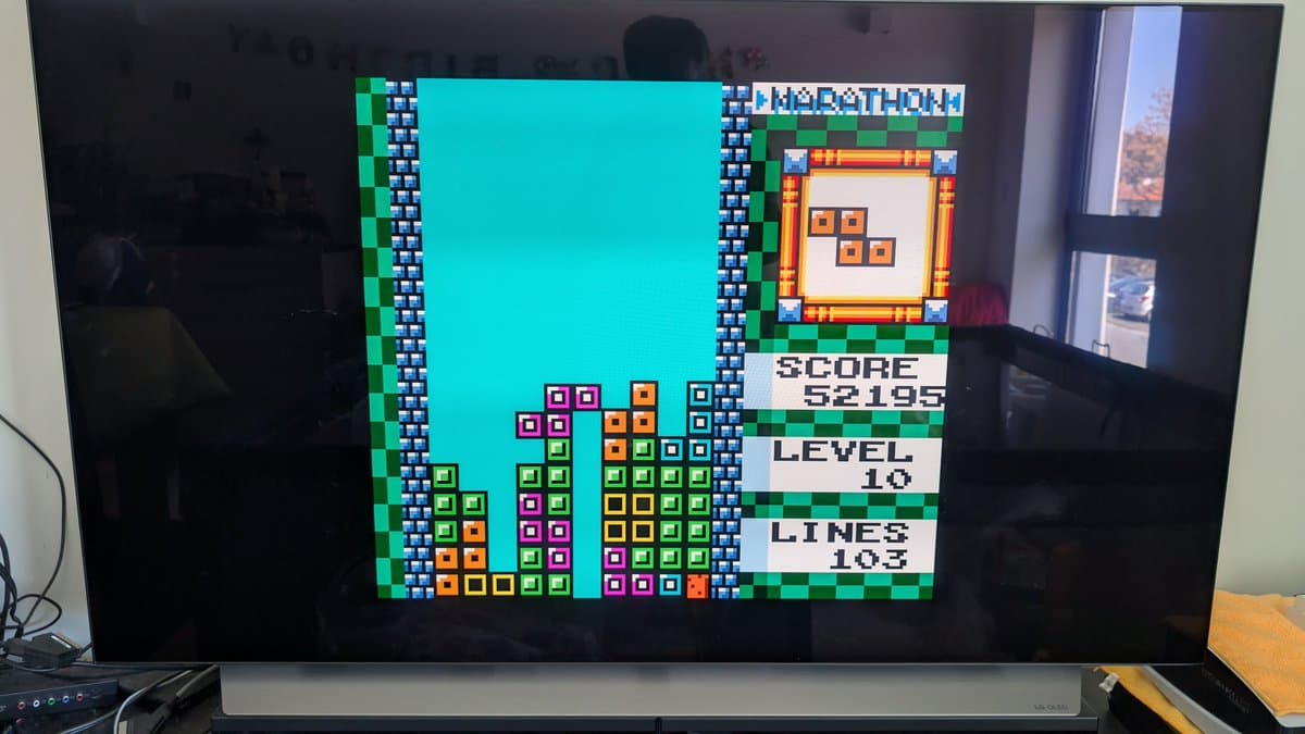 Tetris gameplay on restored silver GameCube showing score 52195, level 10, lines 103 with vibrant block colors and sharp pixel rendering.