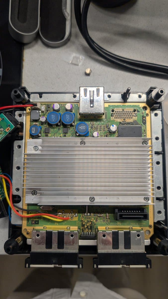 PAL DOL-101 GameCube mainboard with PicoBoot/WiiKey mod installed, showing aluminum heatsink, blue polymer capacitors, and minimal recapping work completed.
