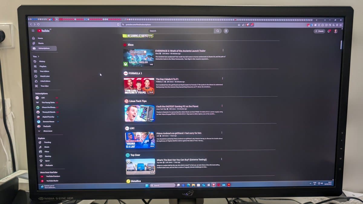 Asus PG27UQ monitor displaying YouTube in dark mode, showing gaming content recommendations on screen.
