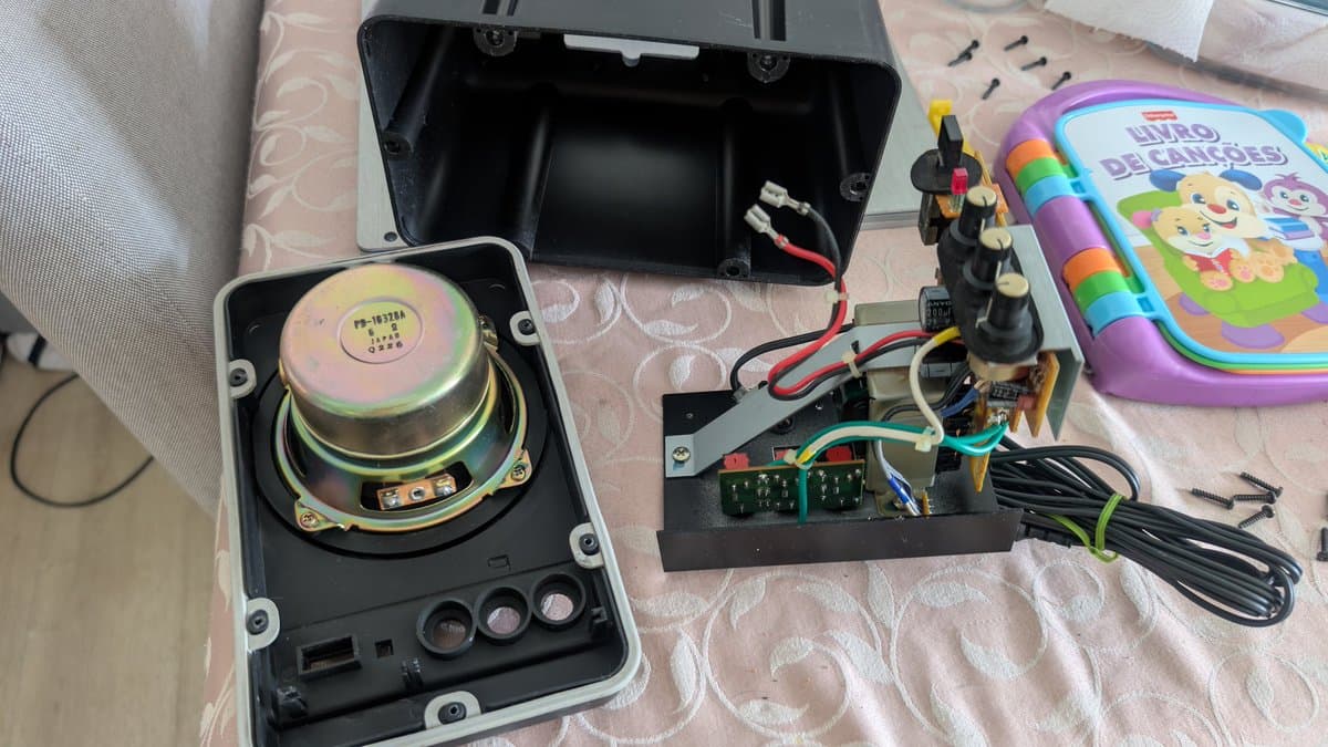 Disassembled BOSS MA-12AV speaker showing exposed driver, circuit board with electrolytic capacitors, and internal wiring during refurbishment.