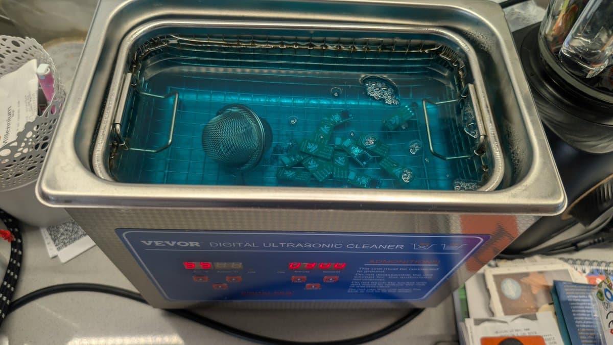 VEVOR digital ultrasonic cleaner with blue solution containing multiple PCBs and a mesh strainer basket during WavePhoenix WaveBird receiver cleaning.