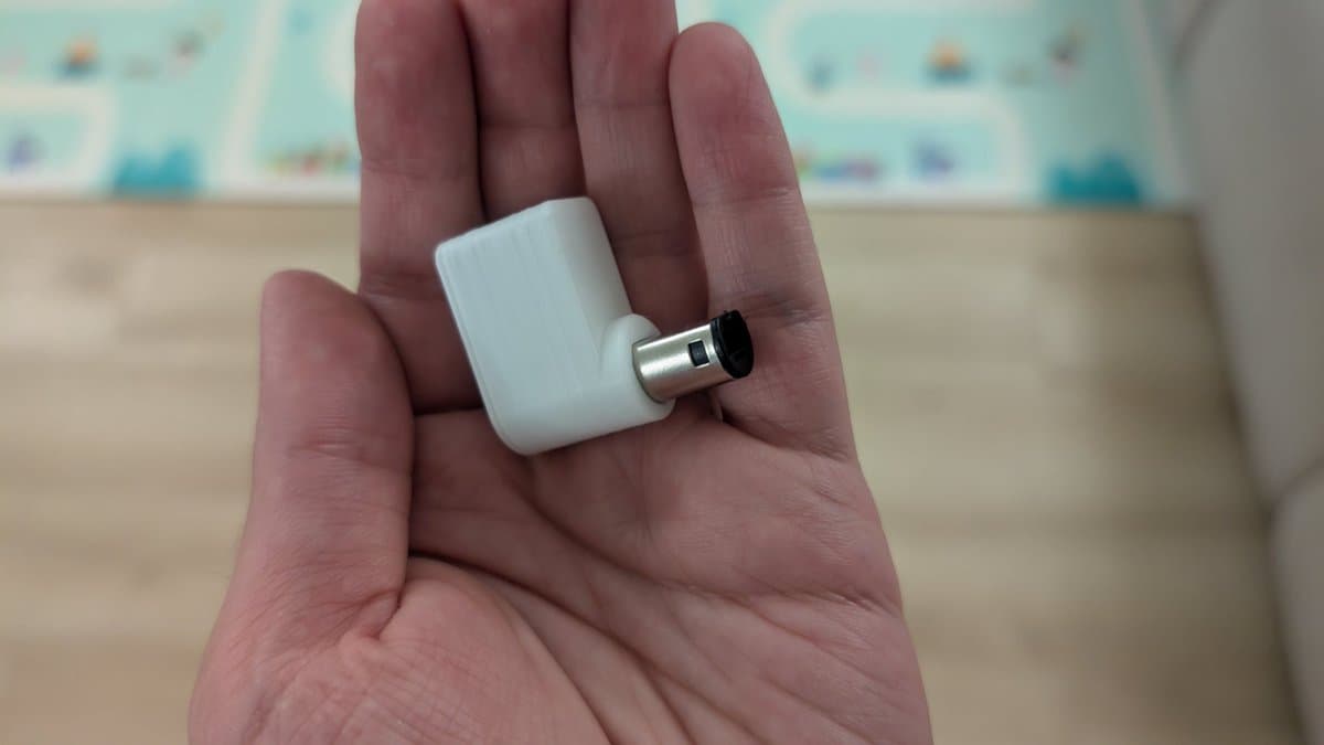 White WavePhoenix receiver with metal connector held in open palm, showing completed build with snap-fit lid design.