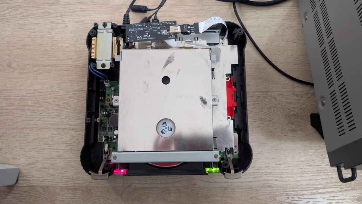 Panasonic FZ-1 internals during restoration: exposed motherboard, PSU with bridged traces, ODE installation with routed ribbon cable, LED indicators visible.