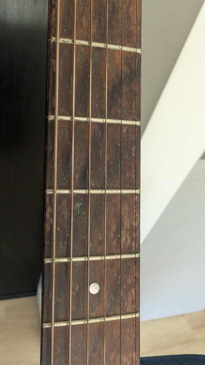Yamaha FX370C fretboard showing cleaned frets with brass frets and inlaid dot position markers after maintenance.