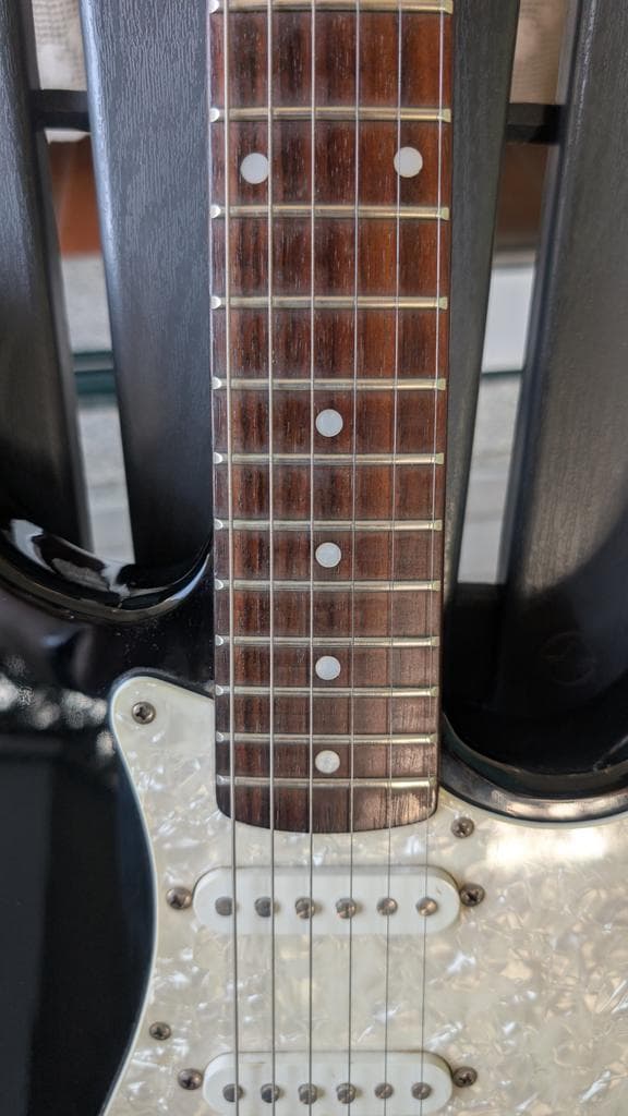 Fender Stratocaster electric guitar with pearl pickguard and rosewood fretboard, cleaned and restored after maintenance work.