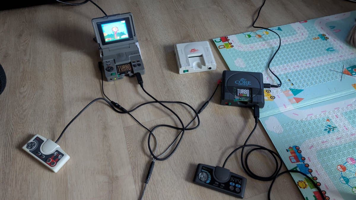 Modded OSSC with Turbo Core module connected to PC Engine via RGB cables, alongside controllers and test equipment on work surface.