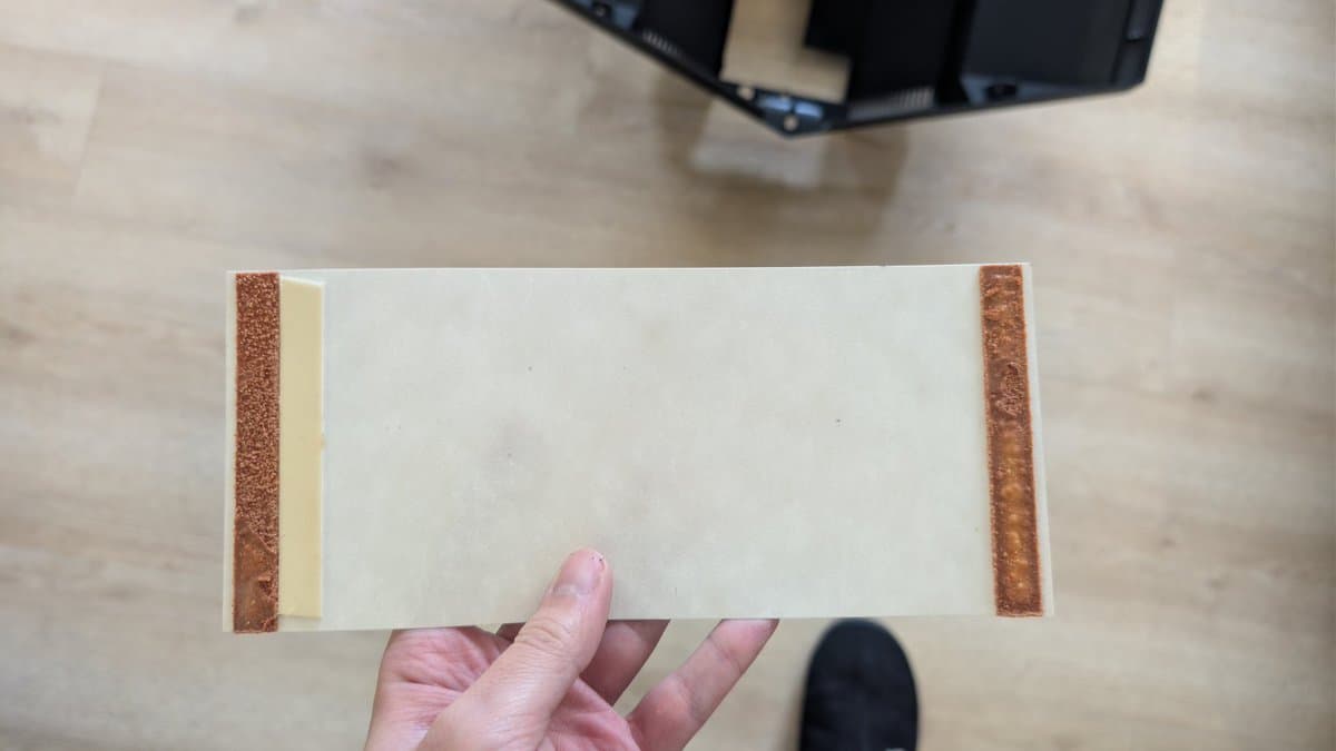 Burnt X2 safety capacitor with charred brown casing held in hand, removed from B&O Beovision 1 CRT television.